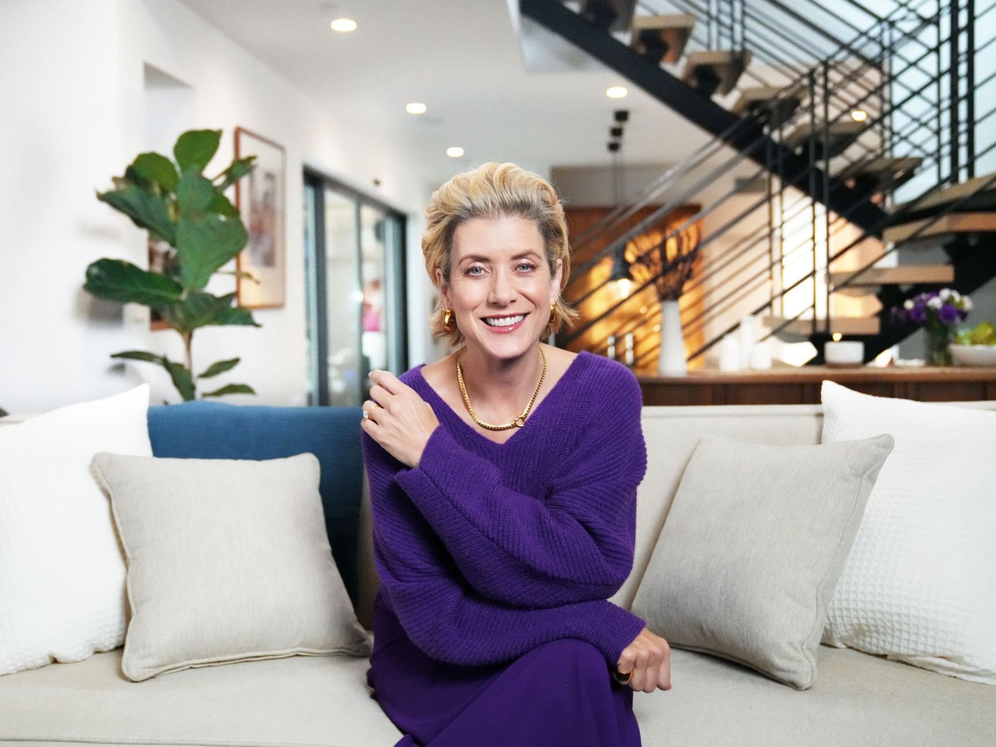 Person smiling on modern living room sofa.