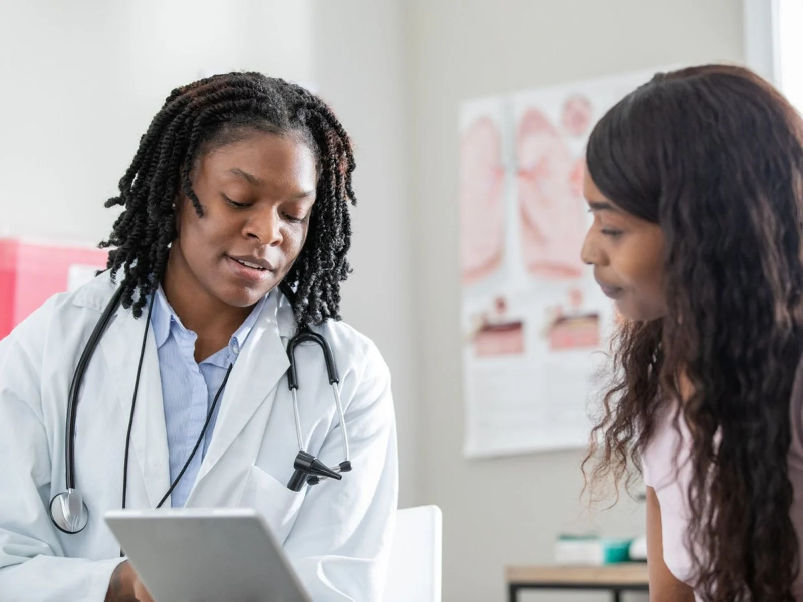 Doctor consulting with a patient using a tablet.