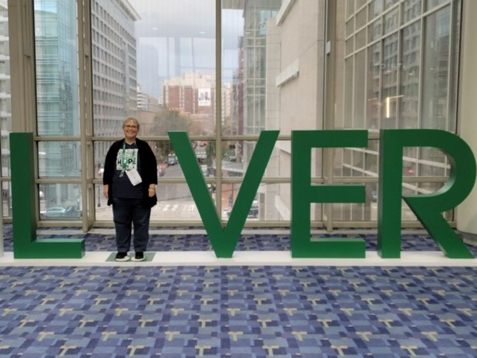Person standing in LIVER sign in building